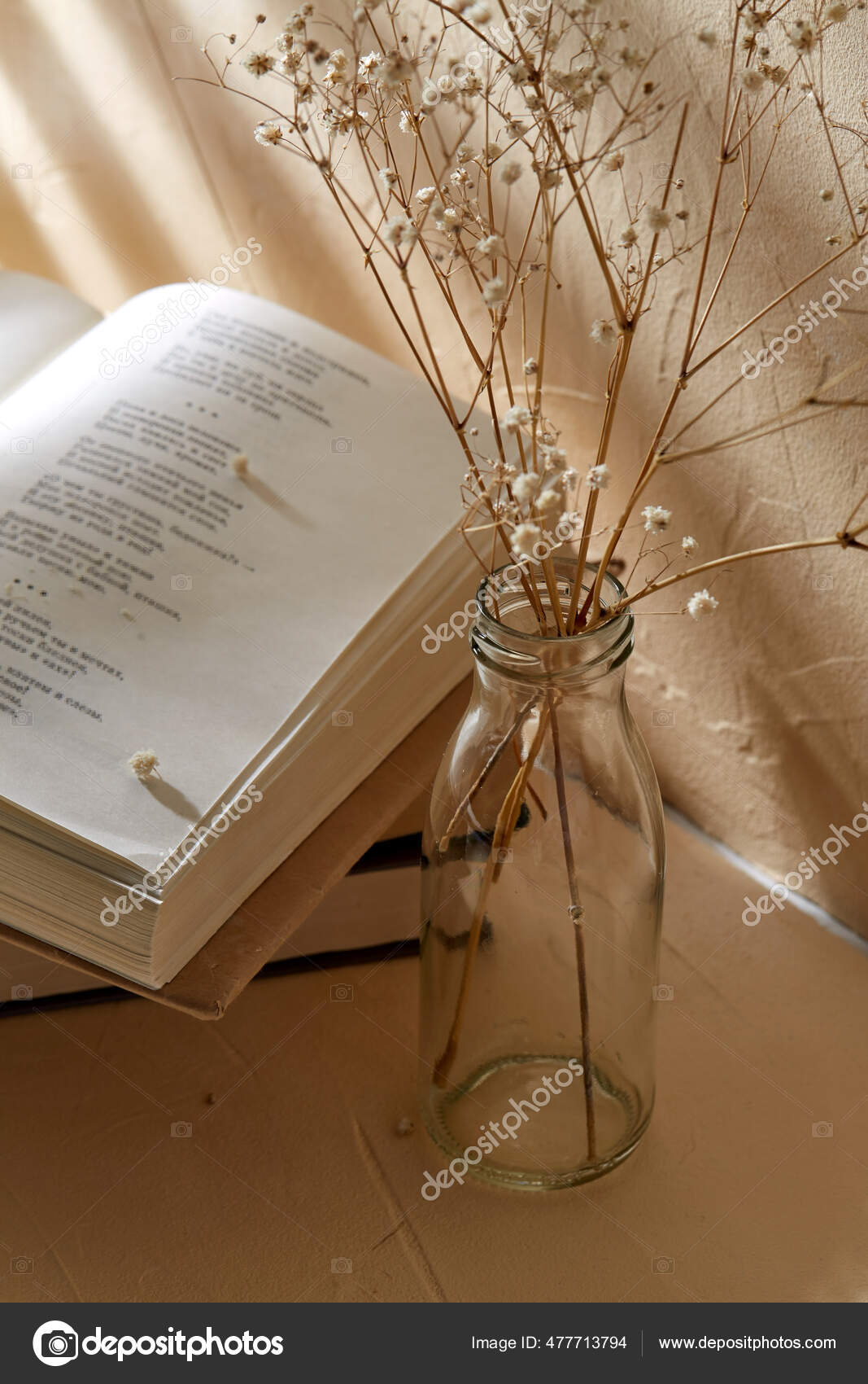 Books and decorative dried flowers in glass bottle Stock Photo by